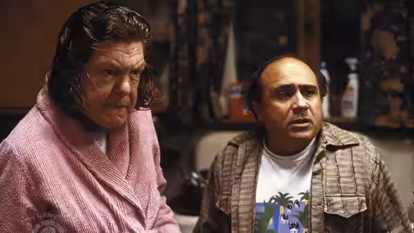 Mrs. Lift (Anne Ramsey) and Owen Lift (Danny DeVito) look on tensely inside a kitchen
