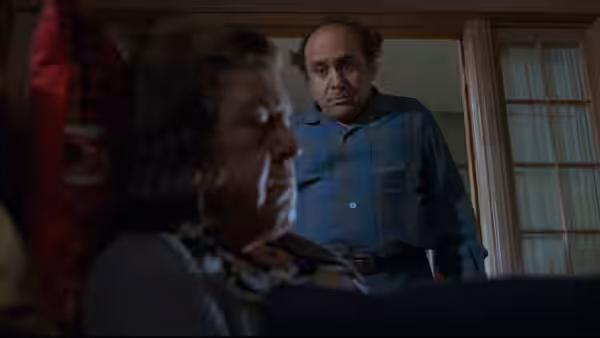 Owen Lift (Danny DeVito) stands over his seated mother inside a dim room