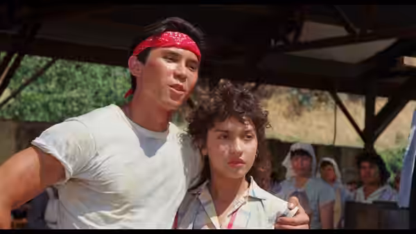 Bob Morales (Esai Morales) stands with Rosie Morales beneath a shelter