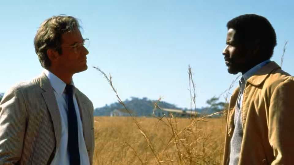 Donald Woods (Kevin Kline) and Steve Biko (Denzel Washington) talk in a dry field