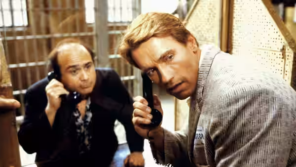 Julius and Vincent listen to telephone receivers inside a room