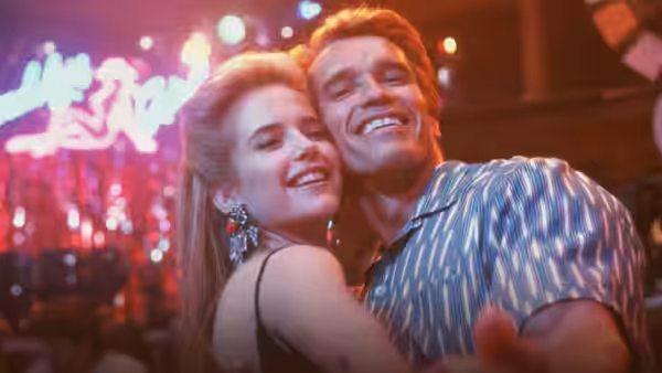 Julius dances with Marnie (Kelly Preston) beneath neon lights