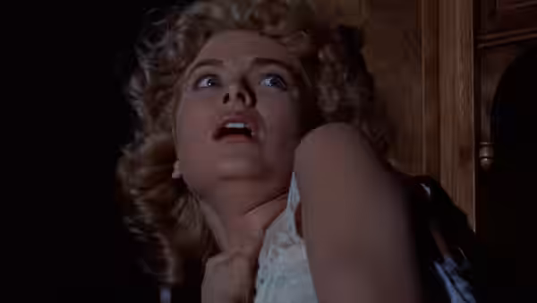 Margot Wendice (Grace Kelly) looks upward in alarm with a hand at her throat