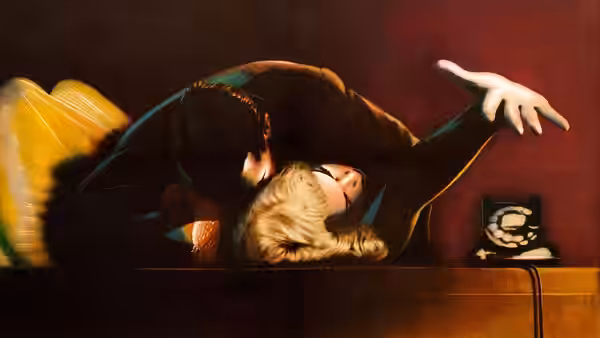 Attacker leans over Margot Wendice (Grace Kelly) sprawled across a desk reaching toward the telephone