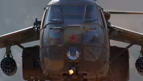 A Soviet attack helicopter advances with its guns firing