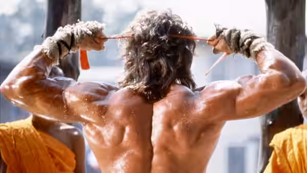 John Rambo (Sylvester Stallone) ties a headband behind his head