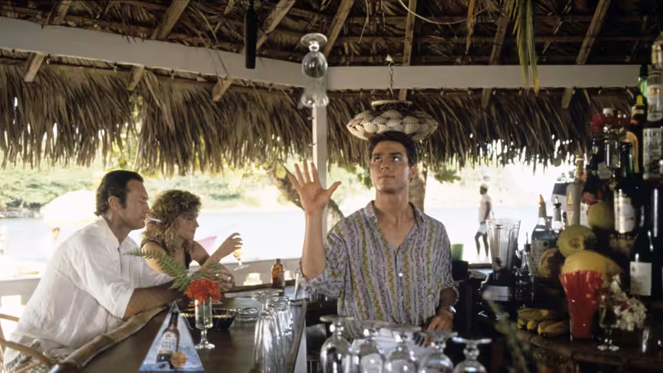 Brian Flanagan juggles a bottle behind a tiki bar as Doug Coughlin and a woman sit nearby