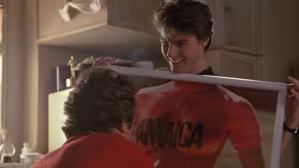 Brian Flanagan grins while holding up a red Jamaica shirt