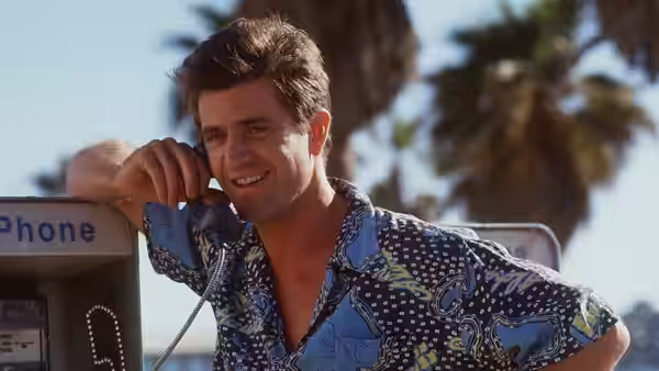 Dale McKussic (Mel Gibson) leans against a payphone outdoors