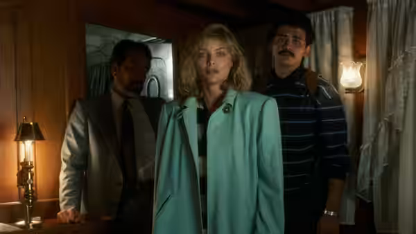 Jo Ann Vallenari (Michelle Pfeiffer) stands between two men inside a dimly lit room