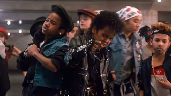 Michael Jackson dances among children in denim and leather outfits