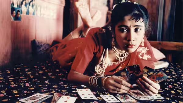 A young woman in red jewelry lies among scattered playing cards