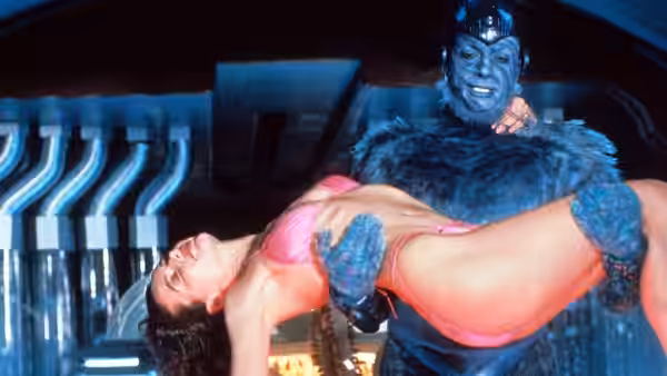 Mac (Jeff Goldblum) carries Valerie (Geena Davis) through a futuristic room