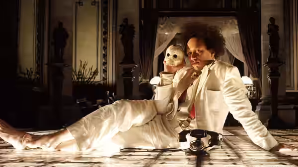 Albert Spica (Michael Gambon) sits beside a reclining woman in a skeletal mask