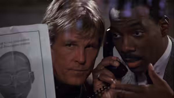 Jack Cates (Nick Nolte) and Reggie Hammond (Eddie Murphy) examine a wanted poster during a phone call