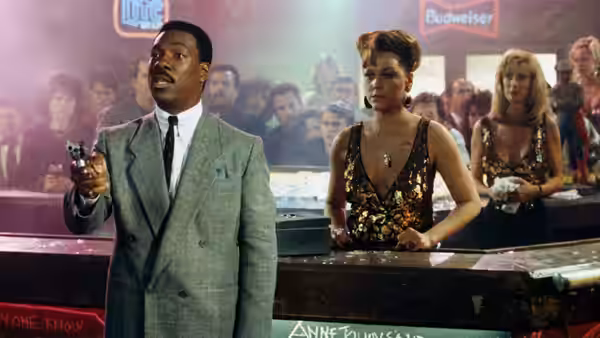 Reggie Hammond (Eddie Murphy) holds a gun beside a woman at a crowded bar