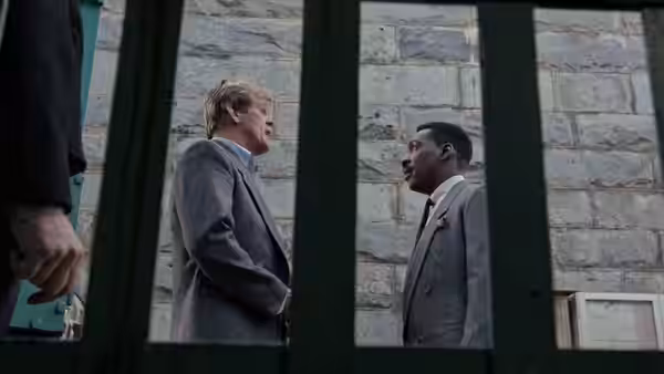 Jack Cates (Nick Nolte) and Reggie Hammond (Eddie Murphy) face each other behind iron bars