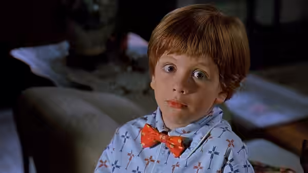 Junior (Michael J. Oliver) sits in pajamas and a bow tie, looking ahead