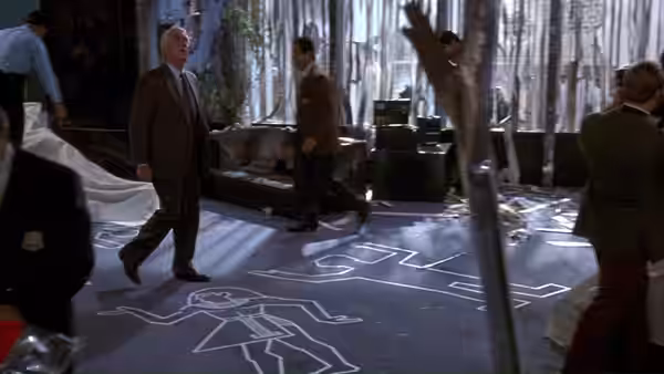 Frank Drebin (Leslie Nielsen) walks through a laboratory as workers gather around a chalk outline
