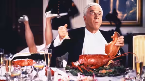 Frank Drebin (Leslie Nielsen) reacts to a lobster during a formal dinner