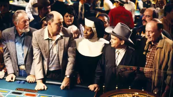 Deloris Van Cartier (Whoopi Goldberg) in a nun's habit at a casino table with gamblers
