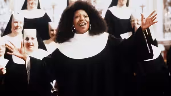 Deloris Van Cartier (Whoopi Goldberg) sings with arms outstretched among the nuns