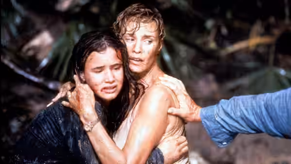 A soaked man embraces a young woman as an outstretched arm reaches toward them