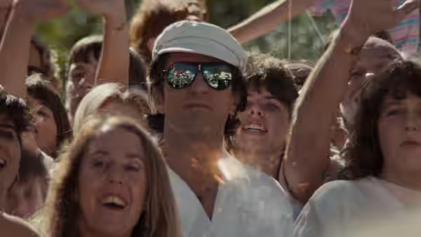 Max Cady (Robert De Niro), wearing a cap and sunglasses, stands amid a cheering crowd