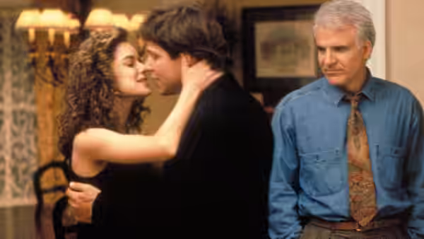 Annie Banks (Kimberly Williams-Paisley) kisses Bryan as George watches nearby