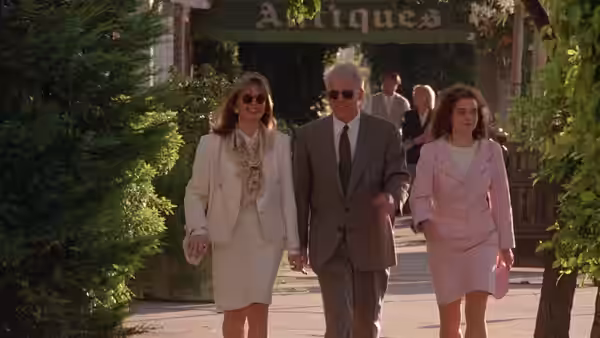George Banks (Steve Martin) walks with Nina and Annie along a leafy sidewalk