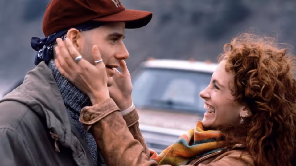 Hilary O'Neil (Julia Roberts) cups a man's face beside a parked car