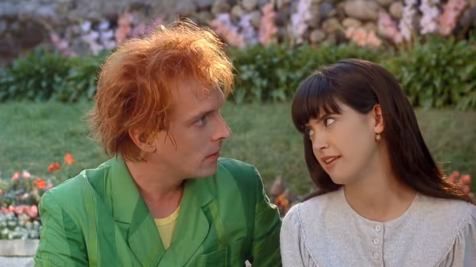 Drop Dead Fred (Rik Mayall) and Elizabeth (Phoebe Cates) sit together in a garden