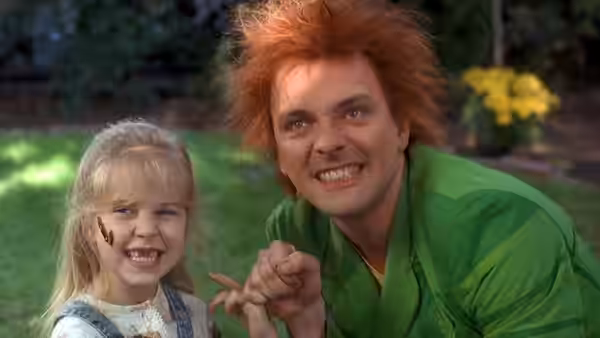Drop Dead Fred (Rik Mayall) crouches beside Young Elizabeth (Ashley Peldon) in a garden