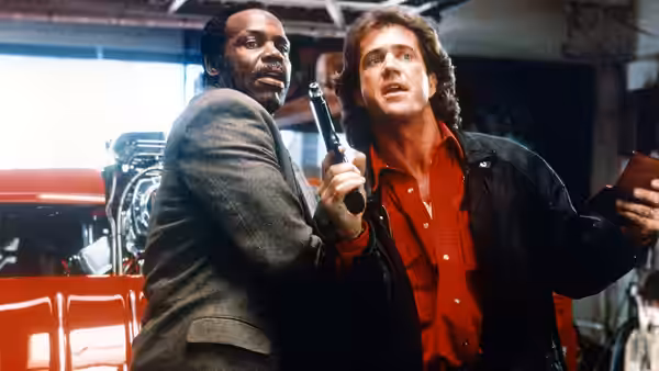 Roger Murtaugh (Danny Glover) and Martin Riggs (Mel Gibson) look upward inside a garage