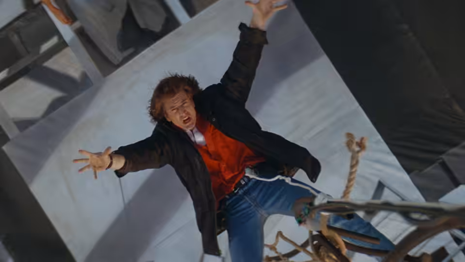 Martin Riggs (Mel Gibson) falls through a collapsing building, arms outstretched