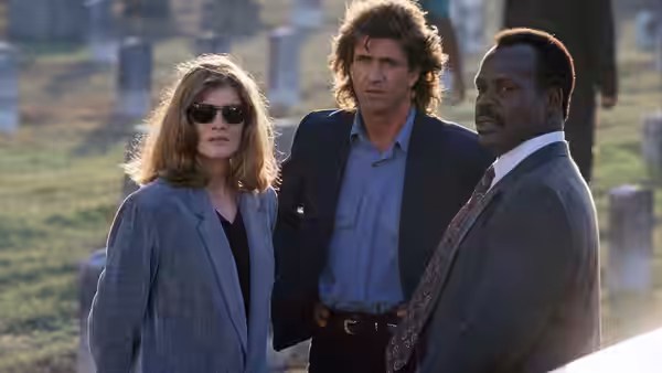 Lorna Cole (Rene Russo), Martin Riggs (Mel Gibson), and Roger Murtaugh (Danny Glover) stand outdoors