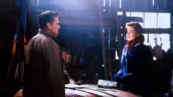 Ed Leland (Michael Douglas) and Linda Voss (Melanie Griffith) face each other across a wooden counter