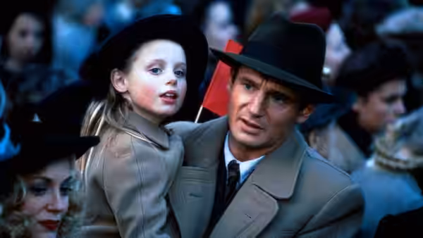 Ed Leland (Michael Douglas) carries a young girl through a crowded street