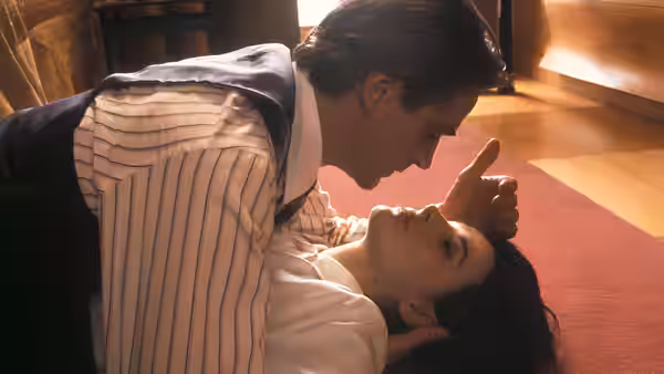 Dr. Stephen Fleming (Jeremy Irons) leans over Anna Barton (Juliette Binoche) lying on a rug