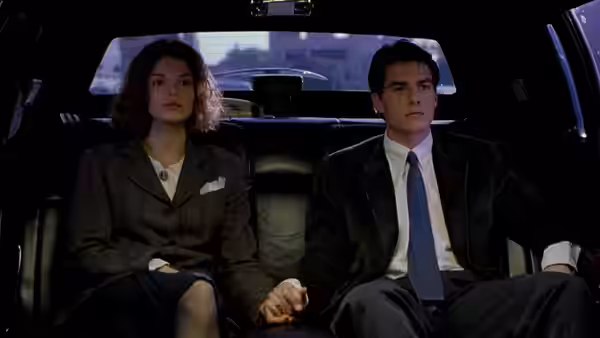 Abby (Jeanne Tripplehorn) and Mitch McDeere (Tom Cruise) sit hand in hand in a car
