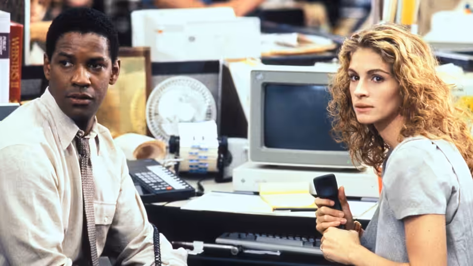 Gray Grantham (Denzel Washington) and Darby Shaw (Julia Roberts) sit beside computers in a newsroom
