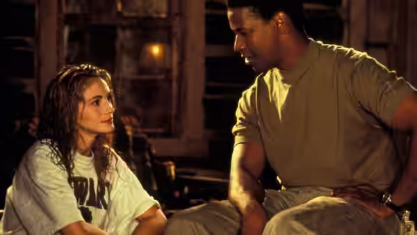 Darby Shaw (Julia Roberts) sits beside Gray Grantham (Denzel Washington) in a dim room