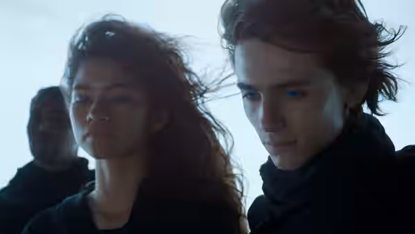 a young woman with flowing red hair beside a young man with blue eyes