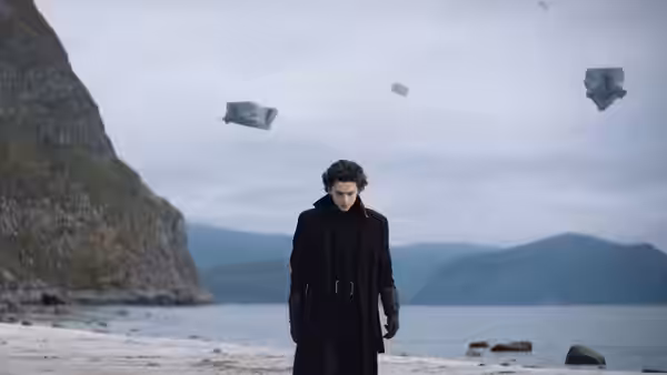 Paul Atreides (Timothée Chalamet) on a beach with floating debris in the sky