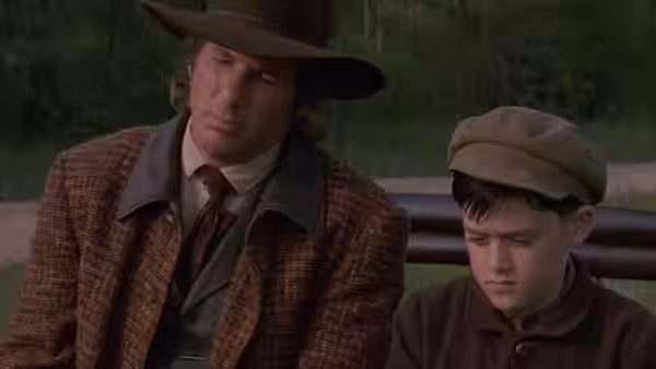 John Sommersby (Richard Gere) and a boy sit together outdoors