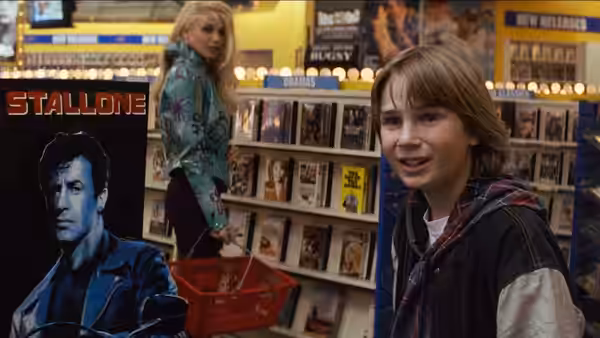 Danny Madigan (Austin O'Brien) smiles in a video store as Whitney (Bridgette Wilson) browses behind him