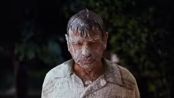 Mr. Wilson (Walter Matthau) stands outdoors with white goo covering his face
