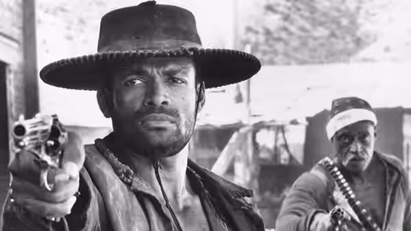 Jesse Lee (Mario Van Peebles) aims a revolver as an armed man stands behind him