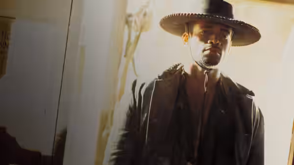 Jesse Lee (Mario Van Peebles) stands in a doorway beneath his wide-brimmed hat