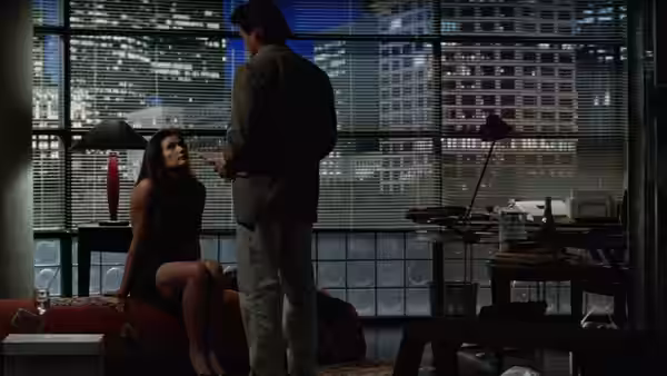 Meredith Johnson sits beside a man in a high-rise office overlooking the city